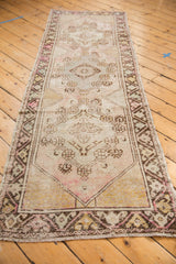 Distressed Oushak runner end, showing fringe, blush, dusty gold, and low pile texture.