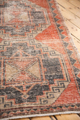 Pale brick red and charcoal geometric gul design on a textured distressed Oushak runner.