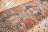 Distressed pale brick red, charcoal, and beige zig-zag border on vintage Oushak runner.