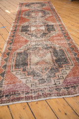 Distressed end of the Vintage Oushak runner, with short off-white fringe and faded purple-red pattern.