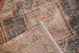 Distressed Oushak runner close-up with worn pile, visible foundation, and folded corner.