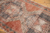 Vintage distressed Oushak rug texture with foundation showing through in brick red, charcoal, and beige.