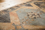 Distressed vintage Oushak runner's geometric medallion, pale rust orange, charcoal brown, and silver tones.