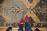 Distressed Oushak runner, pale rust, charcoal, silver geometric medallion, with foundation showing.