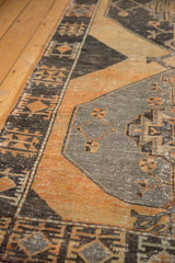 Distressed vintage Oushak rug runner with a charcoal geometric border and worn rust orange field.