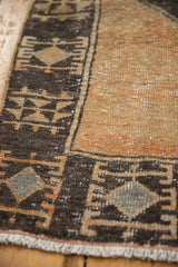 Distressed pale rust orange field with knot heads and geometric charcoal brown border.