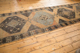 Texture and geometric medallion pattern of a distressed Oushak rug in charcoal, rust, and silver.