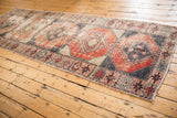 Distressed Oushak rug runner featuring geometric paneled guls in navy charcoal and brick red.