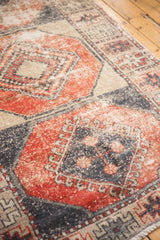 Distressed Oushak runner showcasing paneled geometric guls in faded brick red and navy.