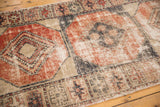 Distressed vintage Oushak runner with worn brick cherry red and navy charcoal paneled guls.