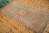 Distressed Oushak rug corner with floral pattern in peach apricot and muted silver.