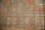 Low pile distressed Oushak runner with peach, silver, grey Rococo motifs.