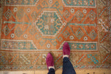 Distressed Melas rug with madder root rust, sky blue geometric patterns, and low pile.