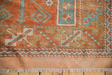 Distressed Melas rug's lower border, featuring madder root rust, sky blue geometric patterns, and fringed edge.