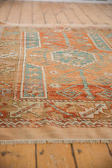 Distressed Melas rug, low pile and short fringe, with geometric rust, ivory, sky blue.