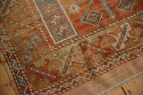 Distressed vintage Melas rug: worn surface, exposed foundation, rust and sky blue border, short fringe.