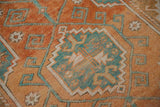 Distressed Melas rug texture with geometric pattern in madder root rust, sky blue.