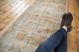 Distressed vintage Oushak runner with low pile, abrashed apricot, ivory, and blue.