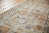 Distressed texture of vintage Oushak runner with worn pile, apricot, ivory, and pale blue.