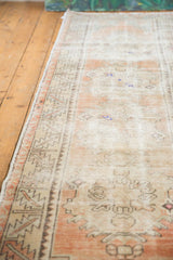 Distressed vintage Oushak runner, faded apricot, ivory hues, exposed foundation.