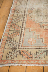 Distressed Oushak runner detail, geometric border, stepped corner, apricot, ivory, and blue.