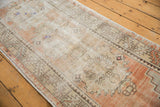 Vintage distressed Oushak rug runner corner, featuring geometric border and abrashed apricot field.