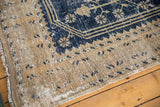 Distressed vintage Oushak rug corner, worn navy blue motifs on antique ivory pile.