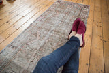Distressed vintage Oushak runner texture, with muted beige, silver, and mauve blush.