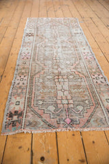 Distressed vintage Oushak runner end, geometric pattern in faded mauve blush and ivory.