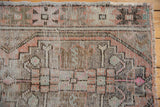 Even wear to knot heads and muted geometric motifs on this distressed vintage Oushak rug.