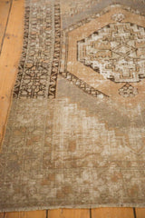 Muted apricot, ivory, and slate distressed texture of vintage Oushak rug, foundation visible.