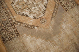 Distressed vintage Oushak rug corner, showing pale apricot, silver slate, and foundation.