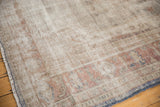 Distressed vintage Oushak rug with worn texture, antique ivory, pale rust, and blue tones.