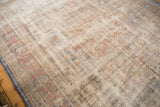 Distressed Oushak rug surface with prominent wear, visible foundation, and muted rust and ivory.