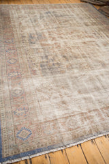 Distressed Oushak carpet showing worn pile, visible foundation, and muted ivory and rust tones.