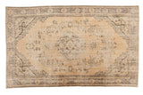 Vintage distressed Oushak carpet, pale beige field, faded Rococo medallion, floral motifs.