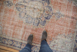 Distressed Oushak rug's even wear and abrashed texture in terracotta, navy, and ivory.