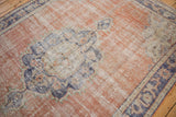 Distressed Turkish Oushak carpet, detail of mostly even wear, exposed foundation, terracotta field.