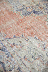 Abrashed texture of distressed Oushak rug, with worn terra cotta, navy, and ivory.