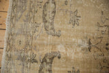 Distressed vintage Oushak rug: fringe, faded vinery, textured field with mostly even wear.