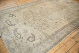 Distressed vintage Oushak carpet with worn texture, faded vinery, and soft neutral colors.