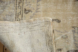 Distressed vintage Oushak rug showing worn pile, tight hand-knotted foundation, and secured edge.