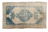 Vintage Distressed Oushak carpet, faded blue serrated medallion on an an ivory field.