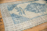Textured distressed blue floral motif and faded ivory border on vintage Oushak rug.