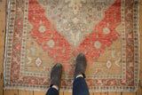 Distressed Oushak rug detail showing terra cotta medallion with oxidized silver floral field.
