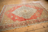 Distressed vintage Oushak rug showing worn terra cotta and sand floral patterns.