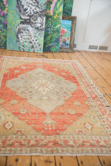 Distressed vintage Oushak rug end with light foundation visible and even wear, in terra cotta and sand.