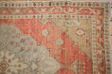 Distressed Oushak rug texture detail with terra cotta, silver field, worn floral patterns, and fringe.