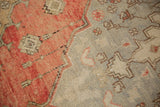 Vintage Distressed Oushak rug detail, terra cotta and silver-beige geometric motifs, light foundation showing.