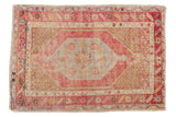 Vintage distressed Oushak rug with lozenge medallion in faded pink, blue, and ivory.